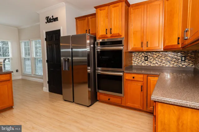 a kitchen with stainless steel appliances granite countertop a refrigerator and a sink