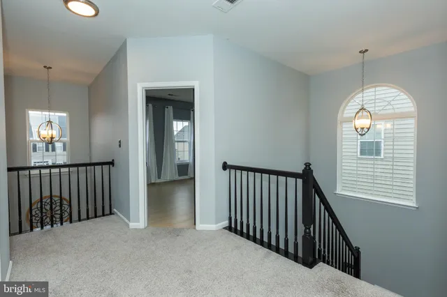a view of a hallway with windows and stairs