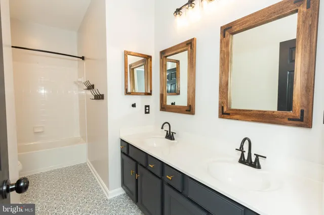 a bathroom with a double vanity sink a mirror and a shower
