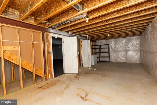 a view of an empty room with closet and entryway