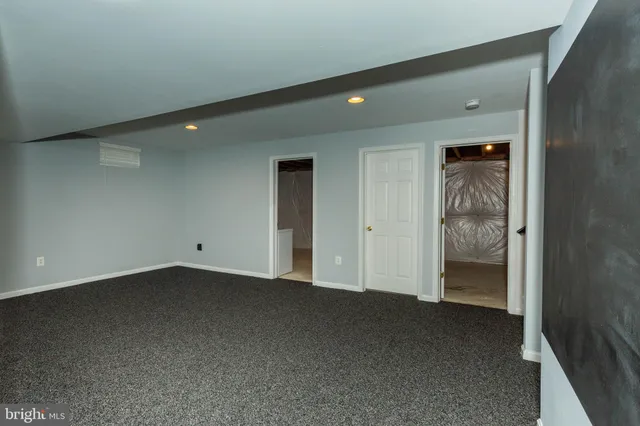 a front view of a house with garden and trees