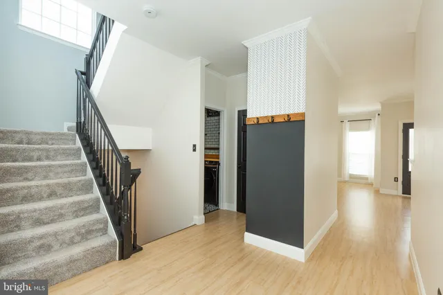 a view of a hallway with wooden floor and staircase