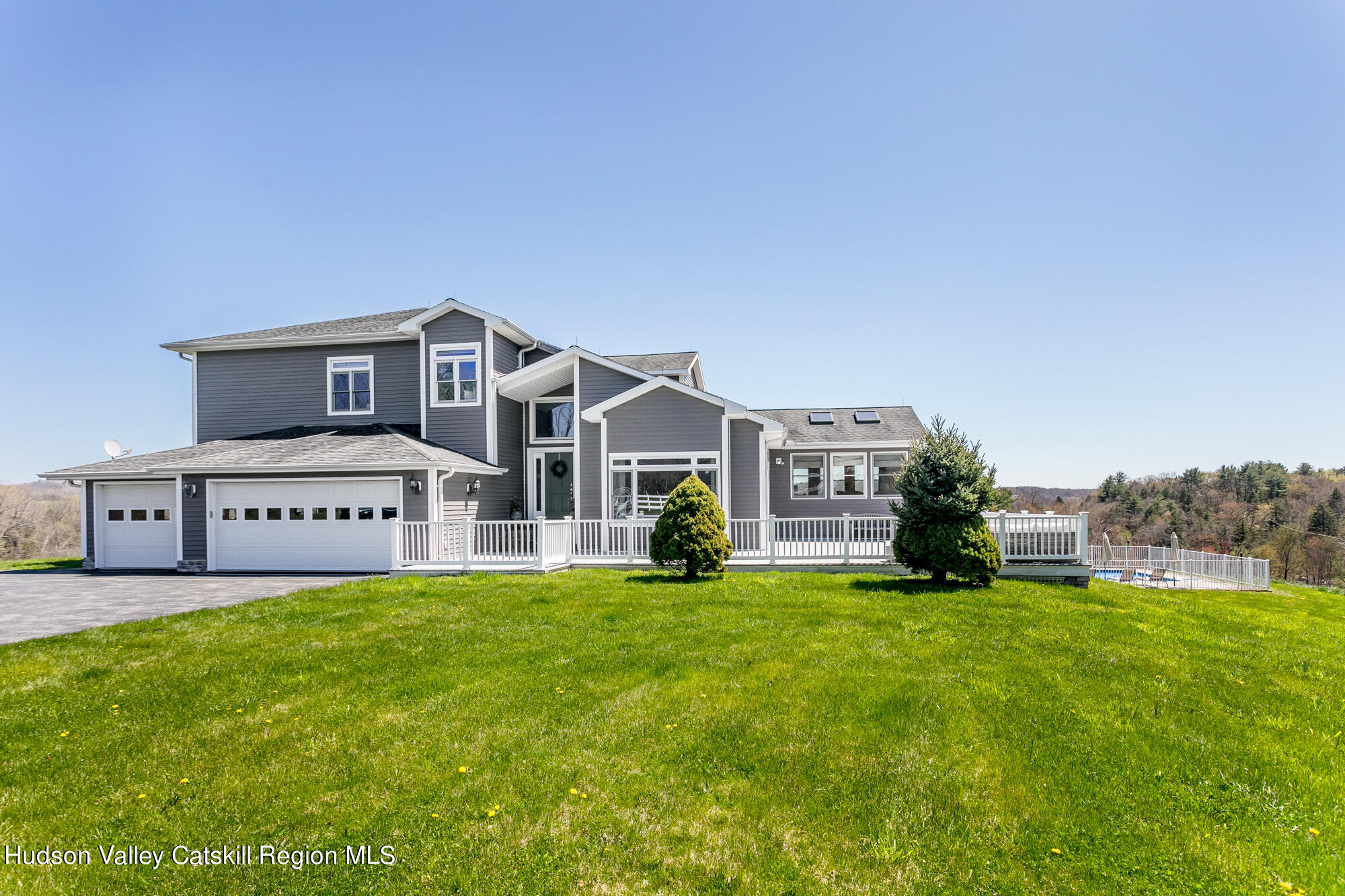 a view of a house with a big yard and large trees