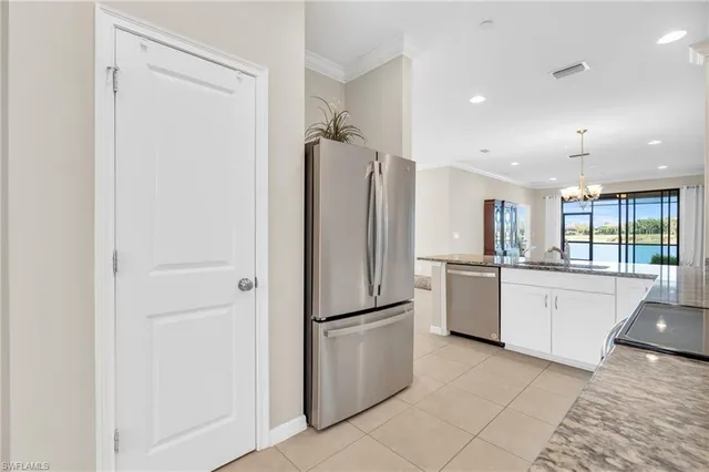 a kitchen with kitchen island granite countertop a sink and refrigerator
