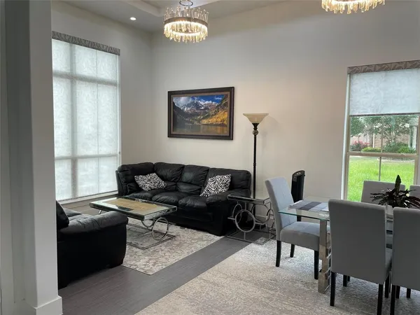 a living room with furniture wooden floor and a large window