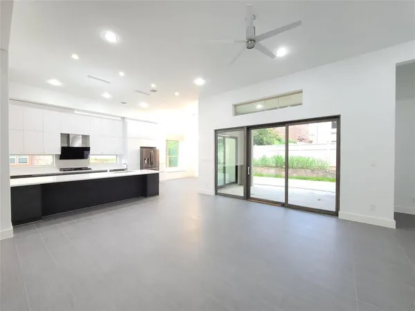 a large kitchen with stainless steel appliances a large counter top a stove and a refrigerator