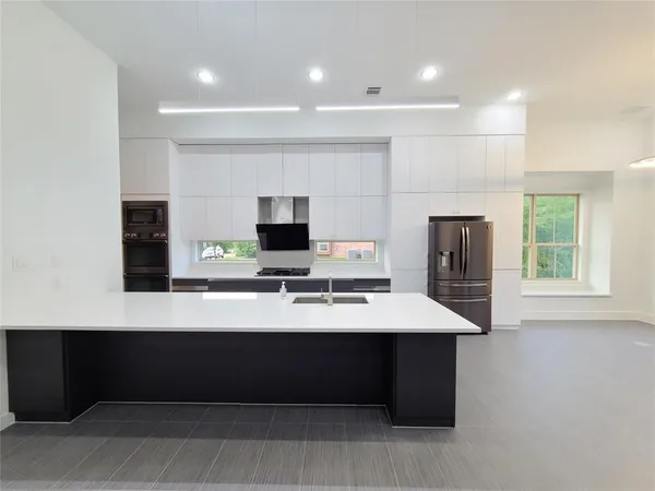 a room with a table chairs and flat screen