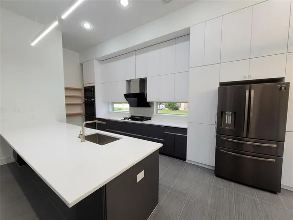 a kitchen with a refrigerator and a stove top oven