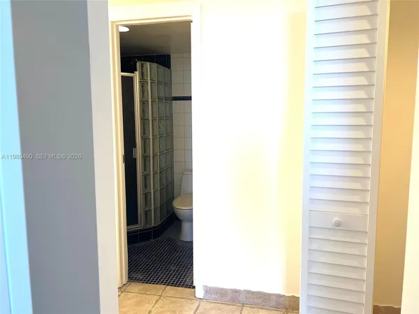 a view of an empty room with a bathroom and a window