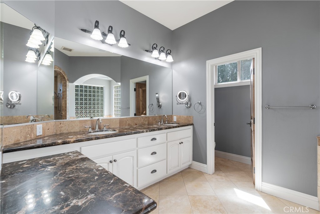 520 Stanton Street Arroyo Grande, CA 93420 - Photo 22 of 45 a spacious bathroom with a granite countertop sink a mirror and a