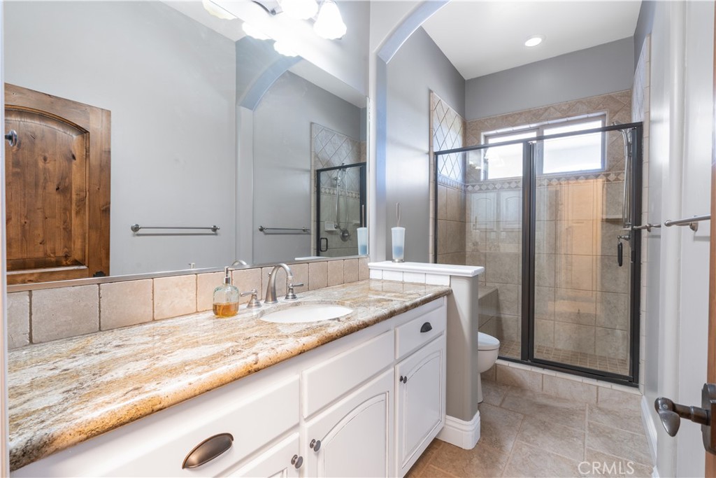 520 Stanton Street Arroyo Grande, CA 93420 - Photo 27 of 45 a bathroom with a granite countertop sink and a mirror