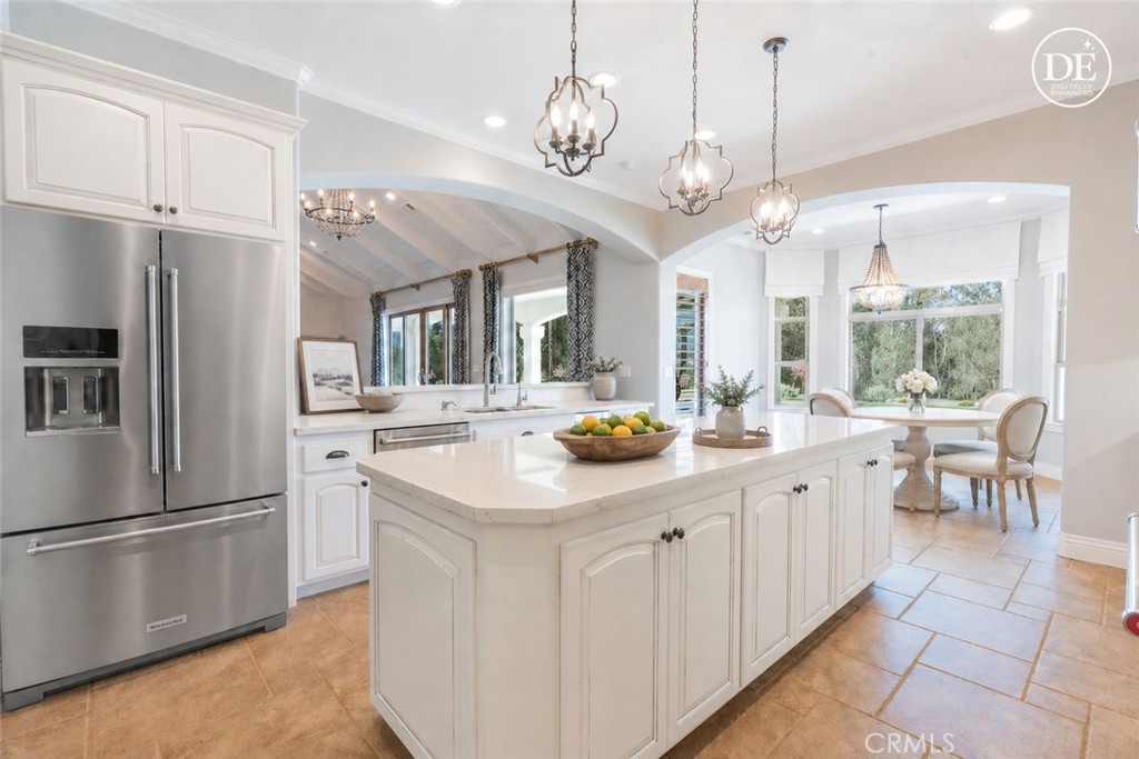 520 Stanton Street Arroyo Grande, CA 93420 - Photo 7 of 45 a kitchen with stainless steel appliances a chandelier open refrigerator a sink dishwasher a dining table and chairs with wooden floor