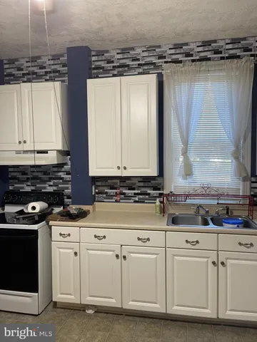 a kitchen with white cabinets and a stove