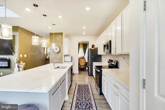 a large white kitchen with stainless steel appliances lots of counter top space