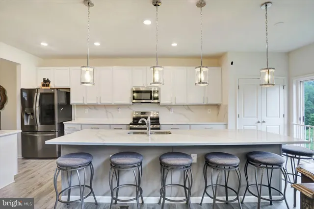 a kitchen with granite countertop a counter space dining table chairs stainless steel appliances and cabinets