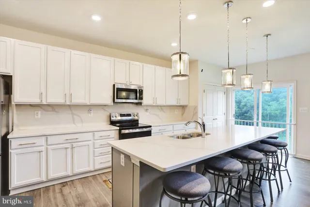 a kitchen with white cabinets and chairs