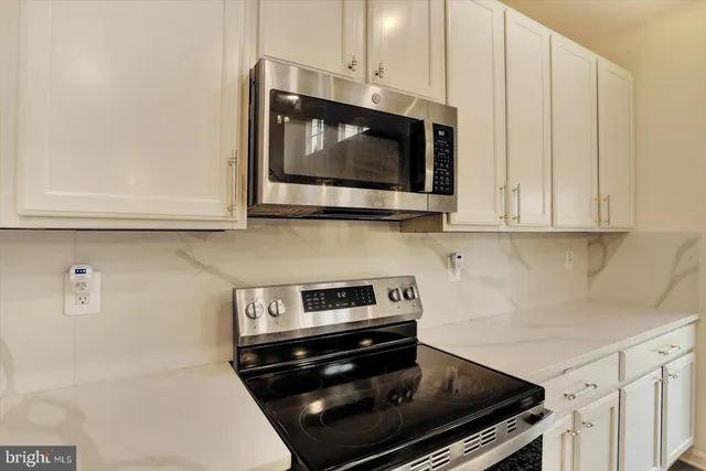 a kitchen with stainless steel appliances a stove a microwave and cabinets