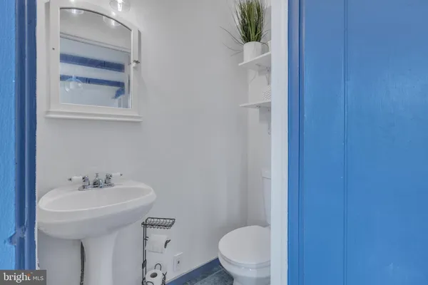 a bathroom with a sink a toilet and a mirror