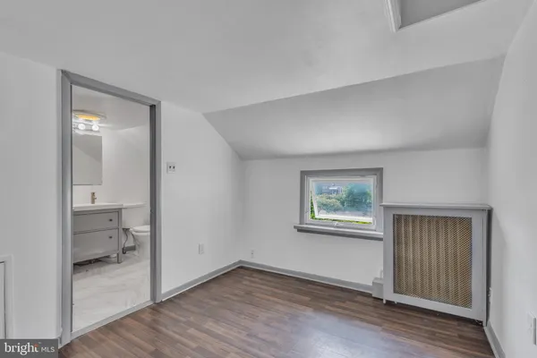 wooden floor in an empty room and a bathroom