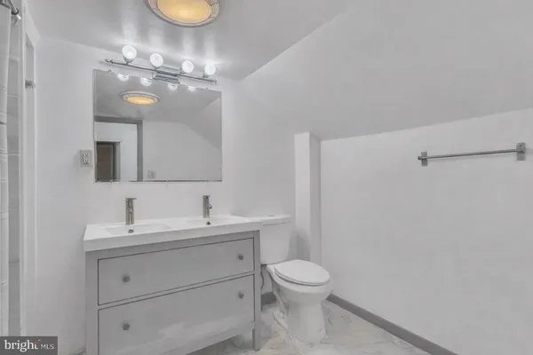 a bathroom with a toilet a sink and mirror