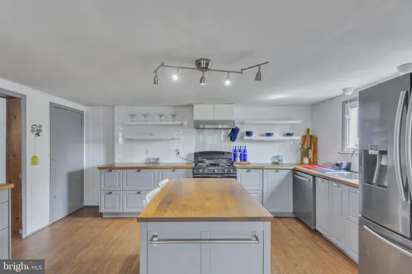 a kitchen that has a lot of cabinets in it and wooden floors