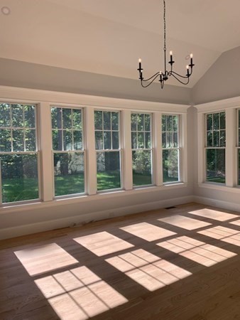 129 Centre Street Dover, MA 02030 - Photo 11 of 18 a view of a livingroom with a white kitchen and a floor to ceiling window