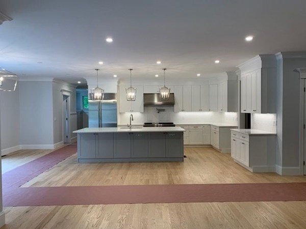 129 Centre Street Dover, MA 02030 - Photo 4 of 18 a large kitchen with kitchen island a sink wooden floor and stainless steel appliances