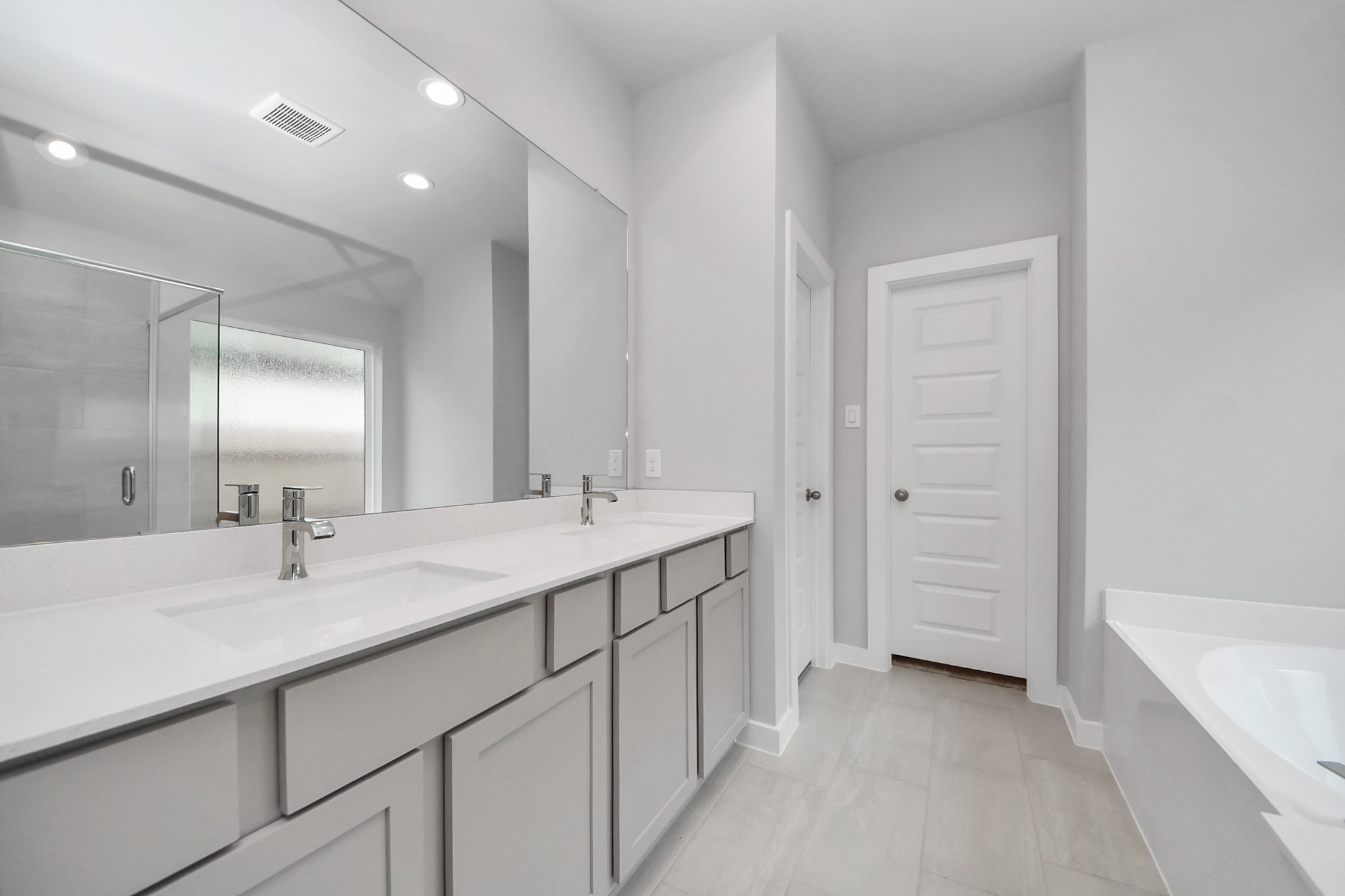 24518 Broad Park Spring, TX 77373 - Photo 24 of 29 Indulge in a spa-like retreat within the confines of this primary bathroom. Delight in a spacious walk-in shower enveloped in stylish tile surround, unwind in a separate garden tub adorned with custom detailing. Sample photo of completed home with similar floor plan. Actual colors and selections may vary.