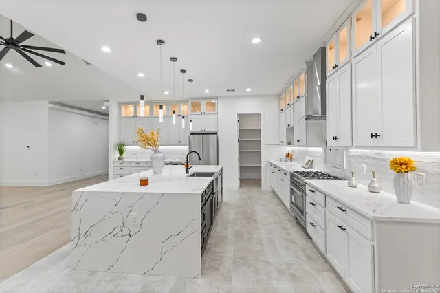 a large white kitchen with stainless steel appliances