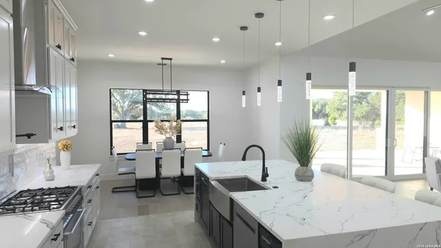 a large kitchen with kitchen island a large counter space a sink stainless steel appliances and cabinets