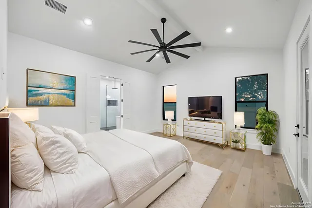 a bedroom with a bed window and a flat screen tv