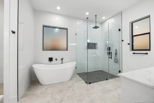 a bathroom with a tub a sink and mirror