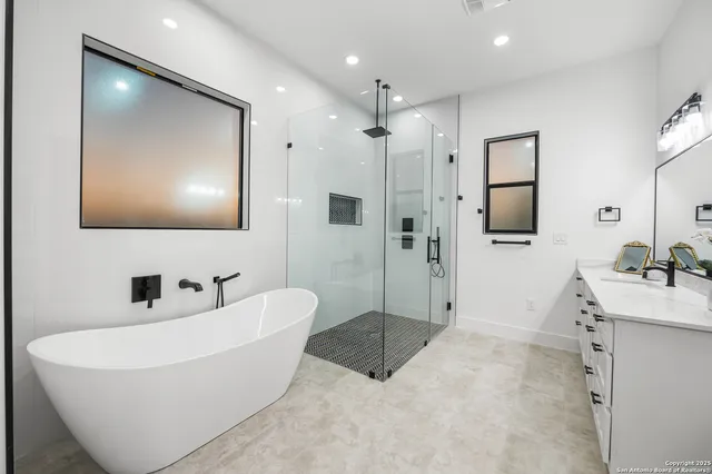 a bathroom with a tub a sink and mirror