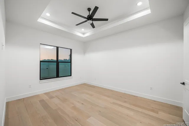 an empty room with windows and fan