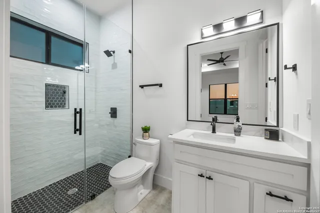 a bathroom with a sink a toilet and shower