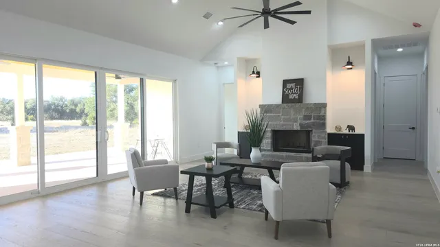 a living room with furniture a fireplace and a floor to ceiling window