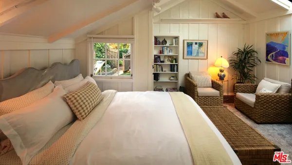 a bedroom with a bed a table and chair