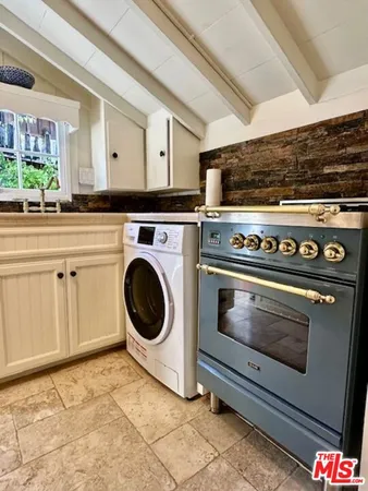 a stove top oven sitting inside of a kitchen