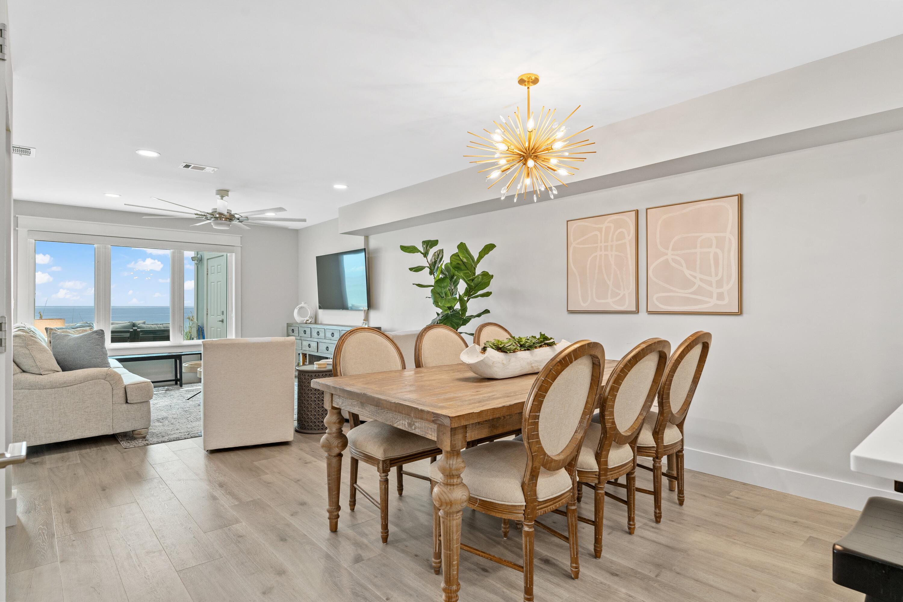 128 Blue Mountain Road, Unit 3 Santa Rosa Beach, FL 32459 - Photo 11 of 33 a view of a dining room with furniture a chandelier and wooden floor