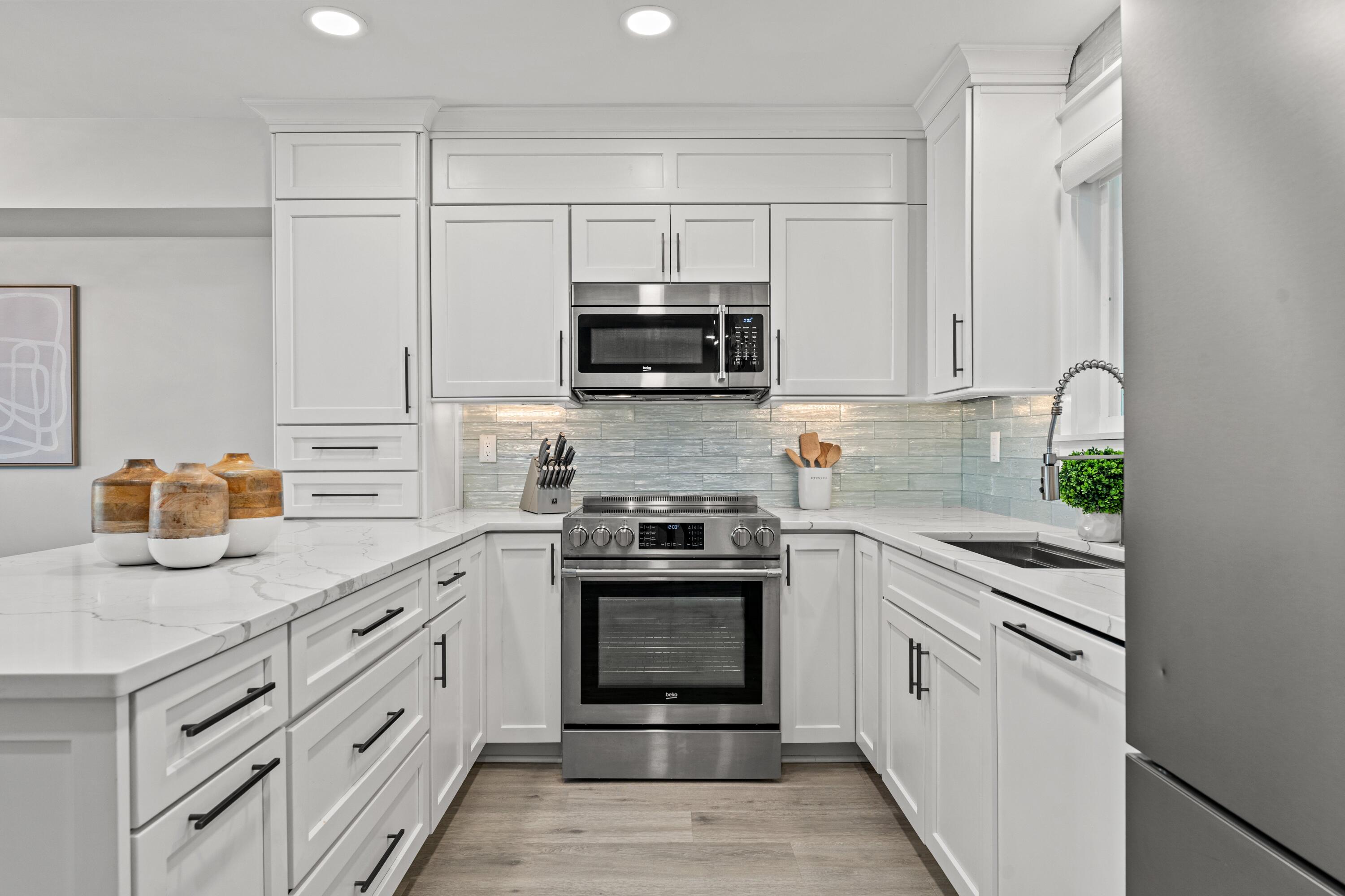 128 Blue Mountain Road, Unit 3 Santa Rosa Beach, FL 32459 - Photo 7 of 33 a kitchen with granite countertop white cabinets and stainless steel appliances