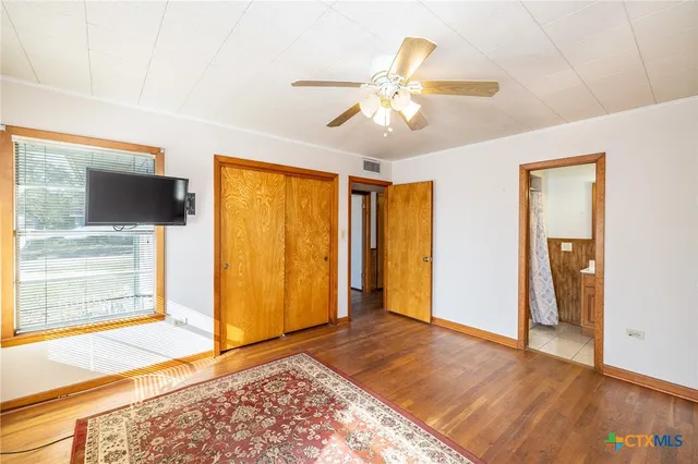 a view of a livingroom with wooden floor and a ceiling fan
