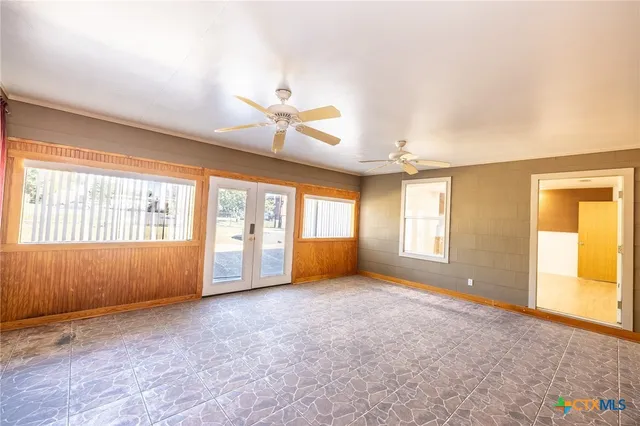 a big room with windows and chandelier fan