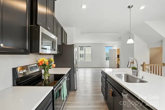 a kitchen with stainless steel appliances a sink a stove and a center island