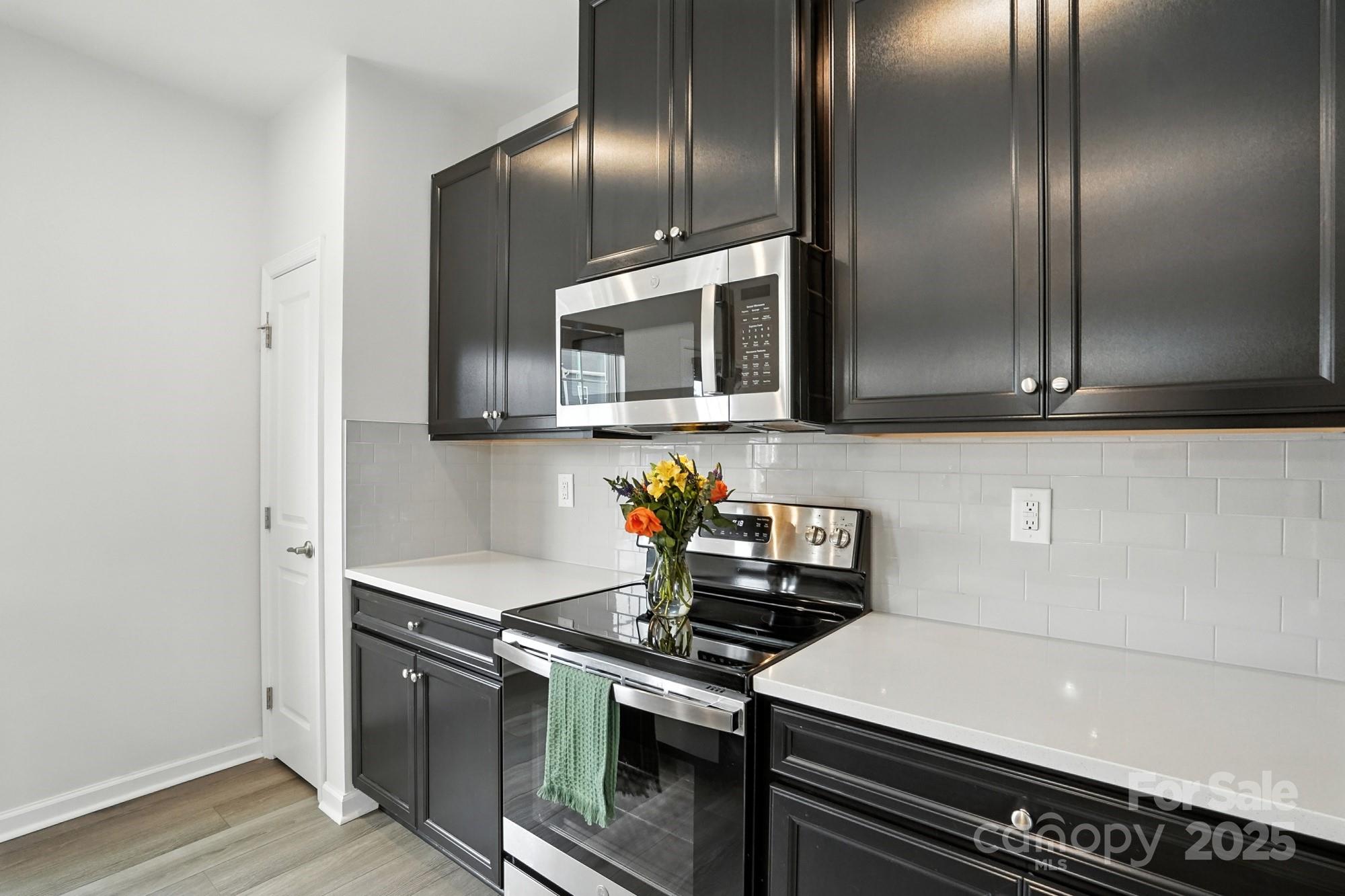 2108 Trout Lily Lane, Unit 198 Matthews, NC 28104 - Photo 17 of 45 a kitchen with granite countertop stainless steel appliances and wooden cabinets