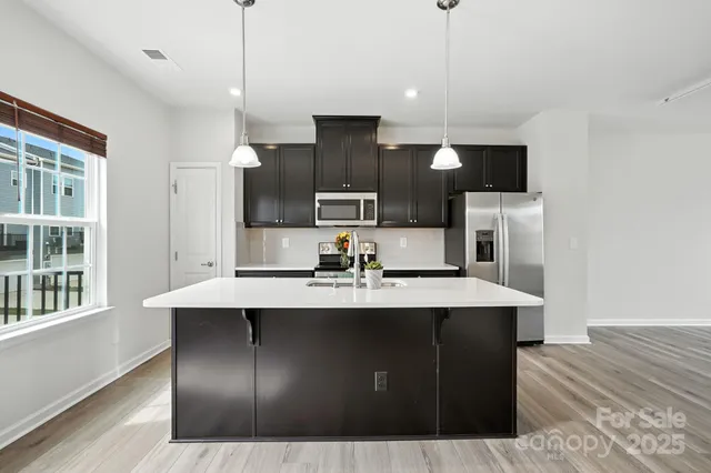 a kitchen with a sink a microwave a refrigerator and cabinets
