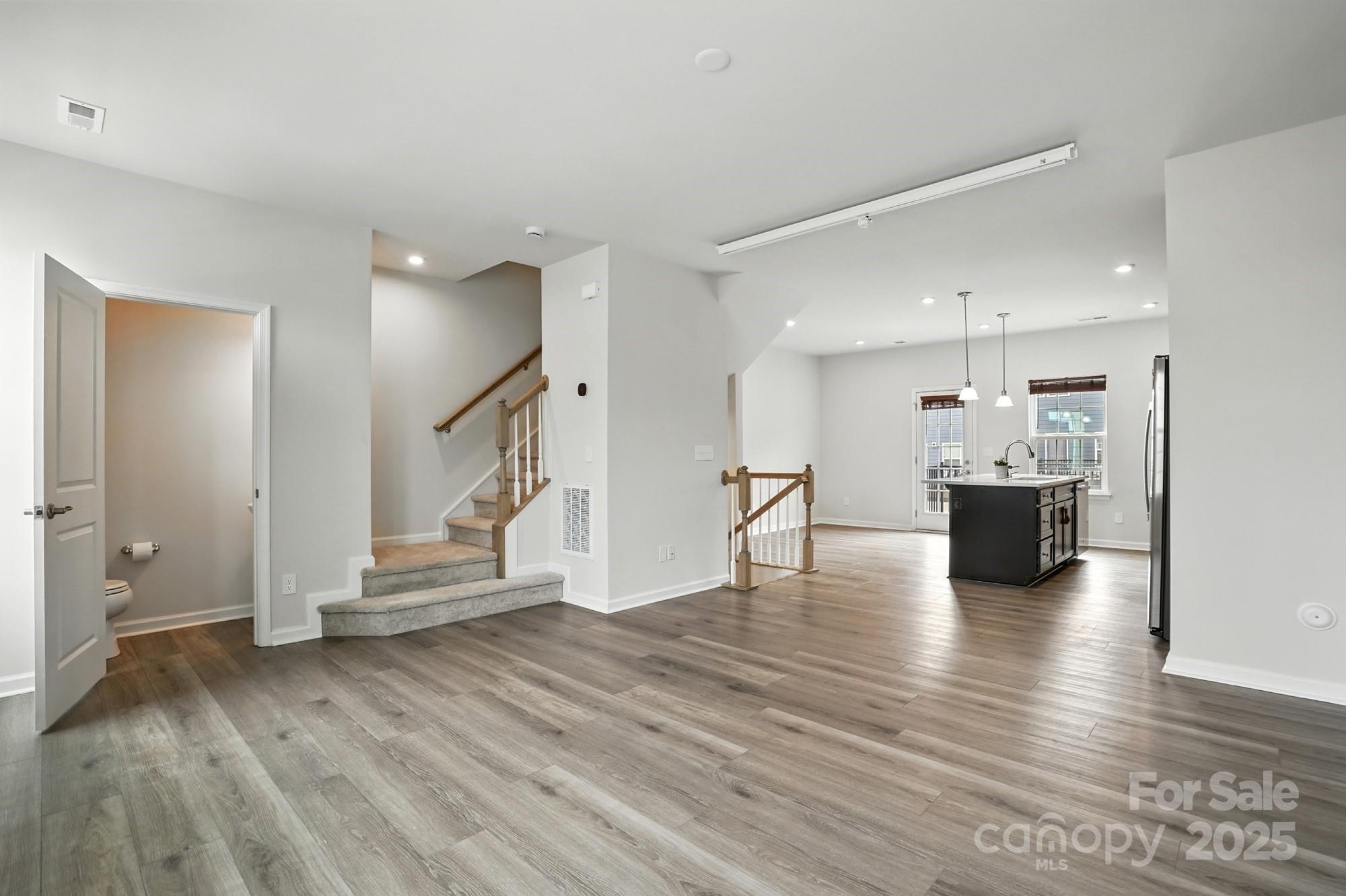 2108 Trout Lily Lane, Unit 198 Matthews, NC 28104 - Photo 21 of 45 a view of a living room and kitchen with furniture wooden floor and windows