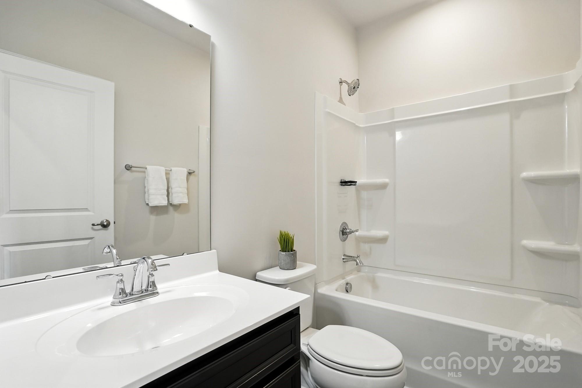 2108 Trout Lily Lane, Unit 198 Matthews, NC 28104 - Photo 36 of 45 a bathroom with a sink a toilet a mirror and shower