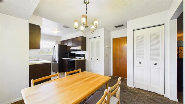 a kitchen with a refrigerator and a stove top oven
