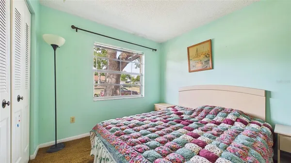 a bedroom with a bed and a painting on the wall