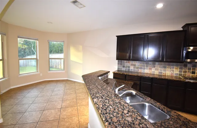a kitchen with granite countertop a sink and a stove
